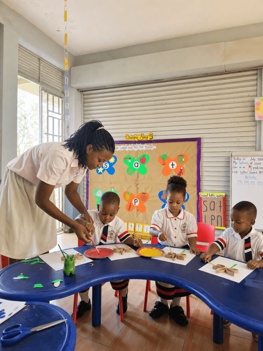An anonymized teacher guiding children through a classroom activity