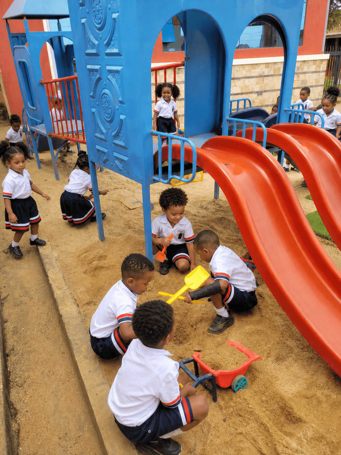 Children playing in sand pit in playground having fun with friends and learning through play.